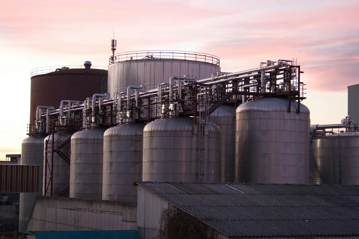 Stainless-steel fuel storage tank farm at dusk — LIGO USA logistics network